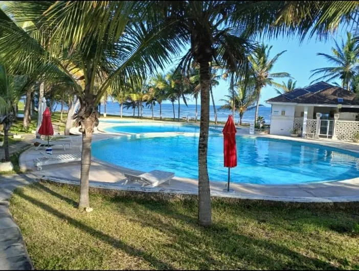 Palm-lined pool and lawn area at a Malindi and Watamu accommodation property