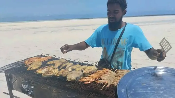 Fresh seafood grilling by the shore as part of a relaxing Mombasa tours beach stop