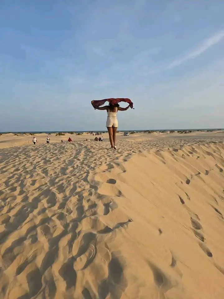 Traveler posing on open sand dunes during a Mombasa tours Dubai Beach excursion